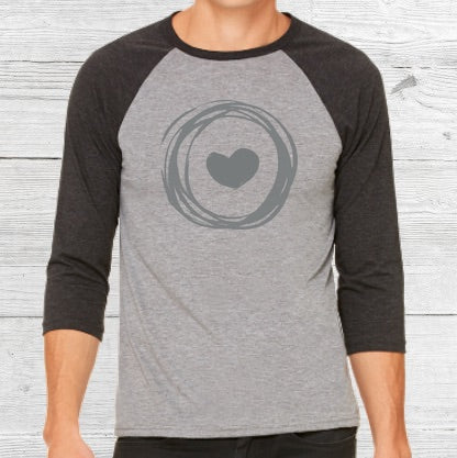 Light gray baseball shirt with dark grey sleeves. Grey Corazon de Vida logo is printed on front.